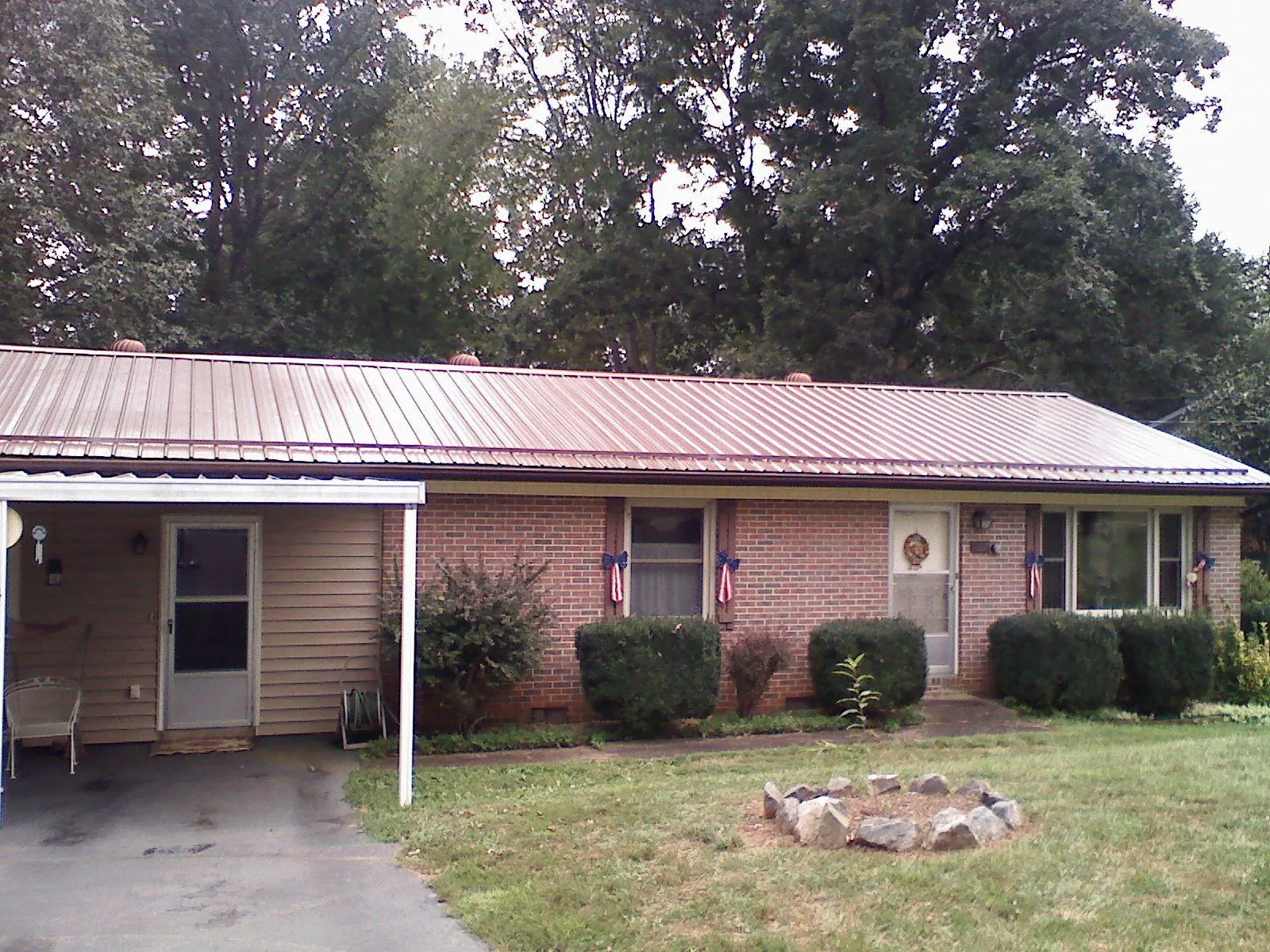 Bronze metal roof and carport on a brick ranch home — Roof Repair work by our crew in Mc Alpin