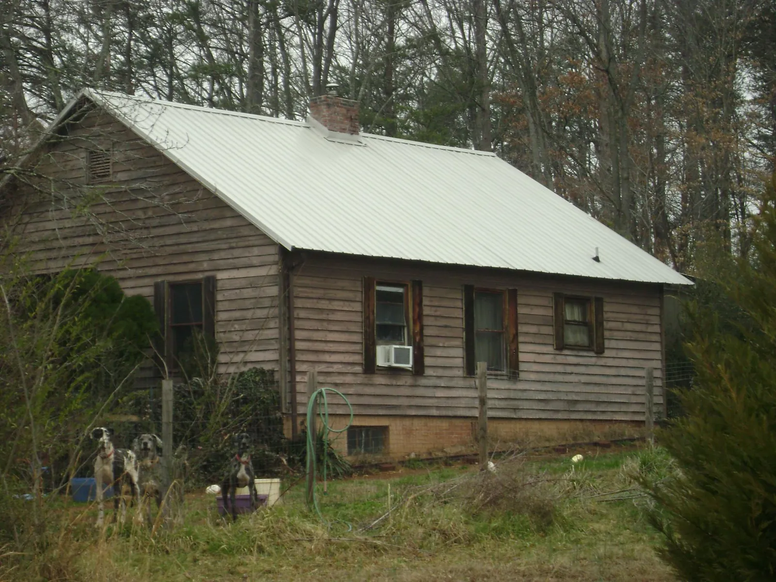 White metal roof on an old wood sided farmhouse, from a Metal Roof Installation job in Mc Alpin